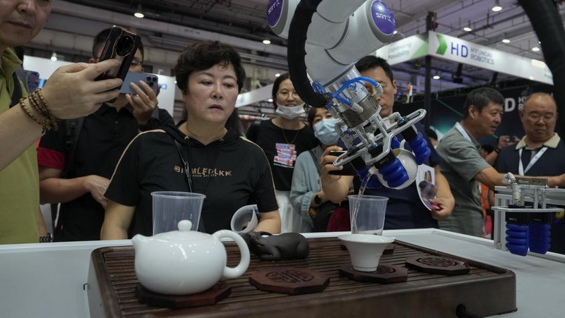 Pekerja mendemonstrasikan robot raksasa pada Konferensi Robot Dunia tahunan di Pusat Pameran dan Konvensi Internasional Etrong Beijing, Rabu, 16 Agustus 2023. (AP Photo/Ng Han Guan)