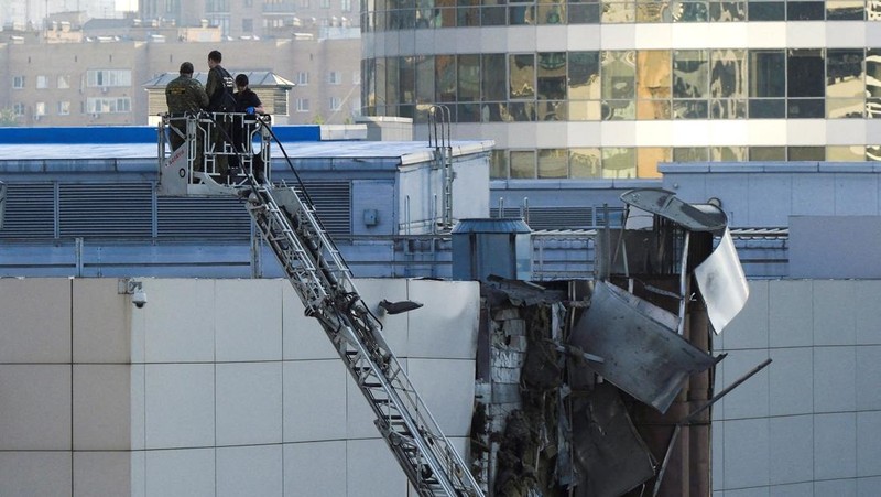 Penyelidik bekerja di dekat atap yang rusak menyusul laporan drone Ukraina yang ditembak jatuh di Moskow, Rusia, 18 Agustus 2023. (REUTERS/Shamil Zhumatov)
