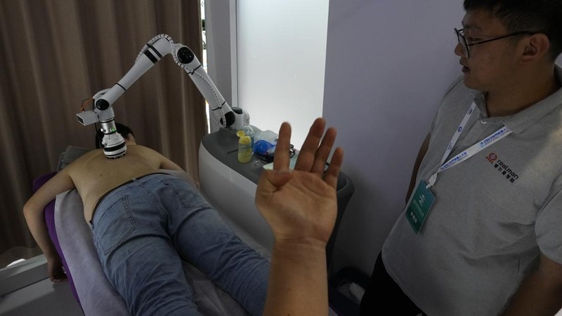 Pekerja mendemonstrasikan robot raksasa pada Konferensi Robot Dunia tahunan di Pusat Pameran dan Konvensi Internasional Etrong Beijing, Rabu, 16 Agustus 2023. (AP Photo/Ng Han Guan)