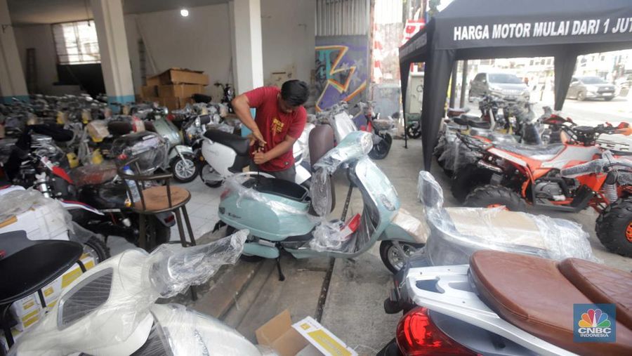 Pekerja merapikan kendaraan motor listrik di salah satu dealer motor listrik, Jakarta, Senin (21/8/2023). (CNBC Indonesia/Muhammad Sabki)