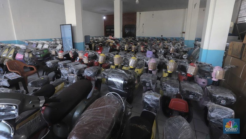 Pekerja merapikan kendaraan motor listrik di salah satu dealer motor listrik, Jakarta, Senin (21/8/2023). (CNBC Indonesia/Muhammad Sabki)