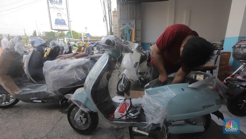Pekerja merapikan kendaraan motor listrik di salah satu dealer motor listrik, Jakarta, Senin (21/8/2023). (CNBC Indonesia/Muhammad Sabki)