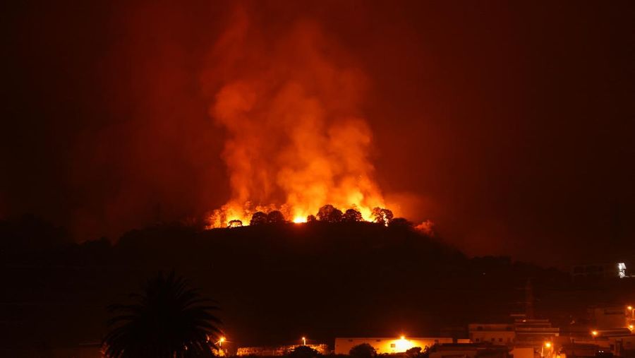 Sebuah pemandangan menunjukkan kebakaran di pegunungan dekat rumah-rumah kosong setelah evakuasi di berbagai desa di utara, saat kebakaran hutan mengamuk di luar kendali di pulau Tenerife, Kepulauan Canary, Spanyol 20 Agustus 2023. (REUTERS/Nacho Doce)