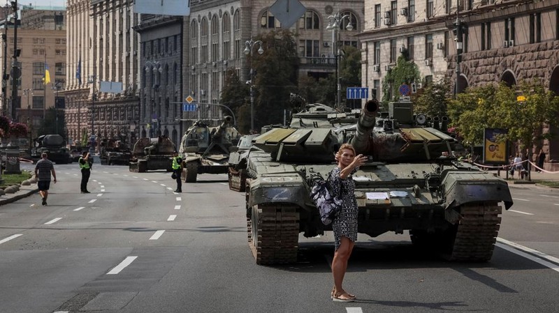 Warga melintas di dekat kendaraan militer Rusia yang hancur dan dipamerkan di sepanjang  jalan utama Khreshchaty, kota Kyiv, Ukraina, Senin (21/8/2023) waktu setempat. (REUTERS/Gleb Garanich)