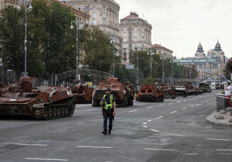 Warga melintas di dekat kendaraan militer Rusia yang hancur dan dipamerkan di sepanjang  jalan utama Khreshchaty, kota Kyiv, Ukraina, Senin (21/8/2023) waktu setempat. (REUTERS/Gleb Garanich)