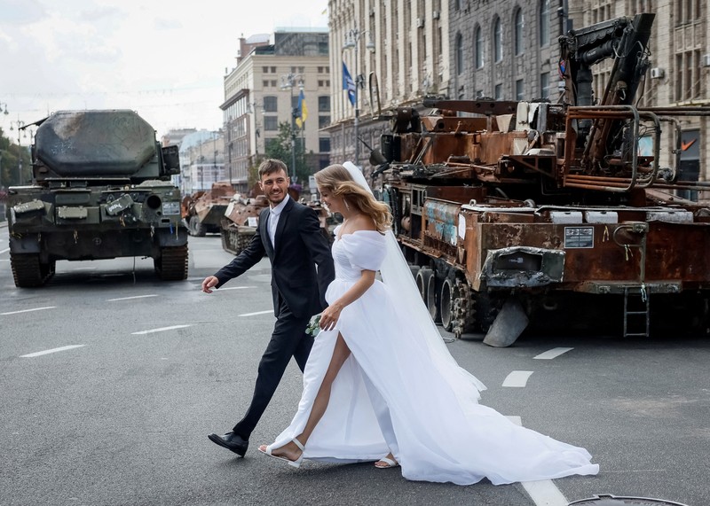 Warga melintas di dekat kendaraan militer Rusia yang hancur dan dipamerkan di sepanjang  jalan utama Khreshchaty, kota Kyiv, Ukraina, Senin (21/8/2023) waktu setempat. (REUTERS/Gleb Garanich)