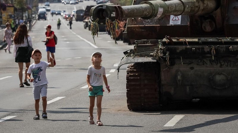 Warga melintas di dekat kendaraan militer Rusia yang hancur dan dipamerkan di sepanjang  jalan utama Khreshchaty, kota Kyiv, Ukraina, Senin (21/8/2023) waktu setempat. (REUTERS/Gleb Garanich)