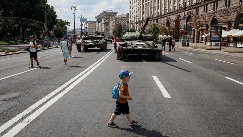 Warga melintas di dekat kendaraan militer Rusia yang hancur dan dipamerkan di sepanjang  jalan utama Khreshchaty, kota Kyiv, Ukraina, Senin (21/8/2023) waktu setempat. (REUTERS/Gleb Garanich)