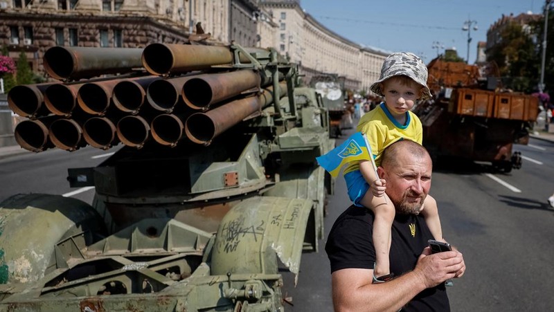 Warga melintas di dekat kendaraan militer Rusia yang hancur dan dipamerkan di sepanjang  jalan utama Khreshchaty, kota Kyiv, Ukraina, Senin (21/8/2023) waktu setempat. (REUTERS/Gleb Garanich)