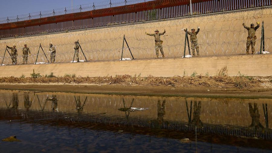 Garda Nasional Texas melakukan pemasangan pagar kawat berduri di tepi sungai Rio Bravo yang merupakan perbatasan antara Amerika Serikat (AS) dan Meksiko pada Selasa (22/8/2023). (REUTERS/Jose Luis Gonzalez)