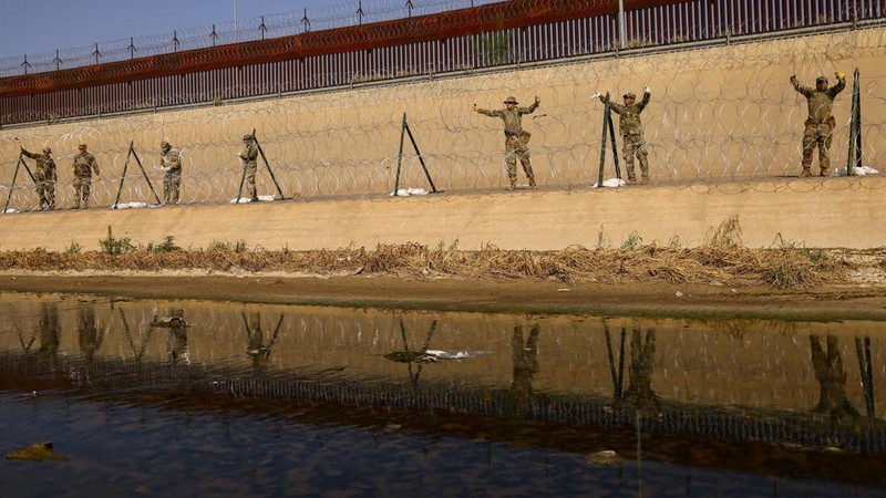 Garda Nasional Texas melakukan pemasangan pagar kawat berduri di tepi sungai Rio Bravo yang merupakan perbatasan antara Amerika Serikat (AS) dan Meksiko pada Selasa (22/8/2023). (REUTERS/Jose Luis Gonzalez)