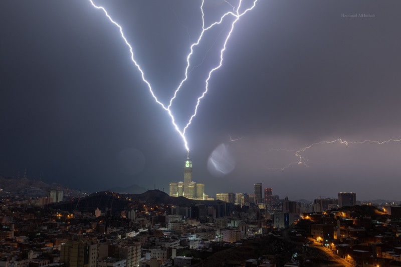 Sebuah gambar yang diambil pada 22 Agustus 2023 menunjukkan petir di atas menara jam Mekkah di Arab Saudi. Badai dahsyat menutup sekolah-sekolah pada tanggal 23 Agustus di wilayah Mekah di kerajaan gurun pasir, tempat Masjidil Haram berada, yang dilanda hujan lebat dan angin semalaman, kata para saksi mata. Sebuah gambar yang diambil pada 22 Agustus 2023 menunjukkan petir di atas menara jam Mekkah di Arab Saudi. Badai dahsyat menutup sekolah-sekolah pada tanggal 23 Agustus di wilayah Mekah di kerajaan gurun pasir, tempat Masjidil Haram berada, yang dilanda hujan lebat dan angin semalaman, kata para saksi mata. (Hammad Al-Huthali / AFP)