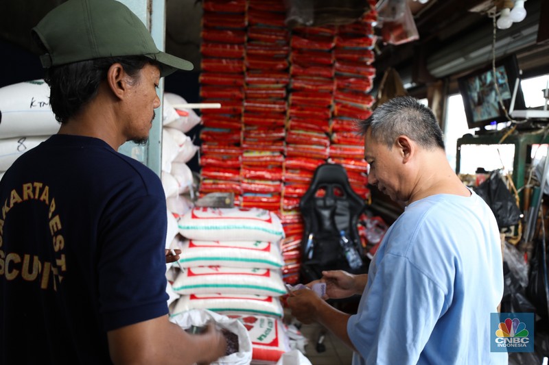 Penjual melayani pembeli beras di pasar Pal Merah, Jakarta, Rabu (23/8/2023). Harga beras terpantau naik hari ini dan kembali cetak rekor tertinggi. (CNBC Indonesia/Tri Susilo)