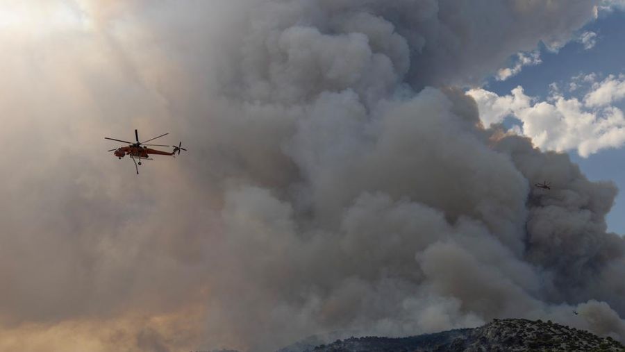 Petugas pemadam kebakaran melihat api yang berkobar di Gunung Parnitha, di Athena, Yunani, 24 Agustus 2023. (REUTERS/Nicolas Economou)
