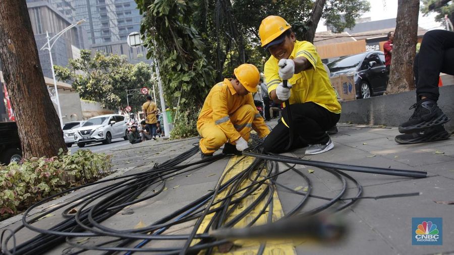 Petugas dari DInas Bina Marga DKI Jakarta melakukan pemotongan kabel semrawut di Sepanjang jalan Senopati, Kebayoran Baru, Jakarta Selatan, Kamis (24/8/2023). (CNBC Indonesia/Muhammad Sabki)