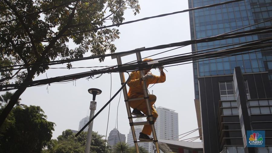 Petugas dari DInas Bina Marga DKI Jakarta melakukan pemotongan kabel semrawut di Sepanjang jalan Senopati, Kebayoran Baru, Jakarta Selatan, Kamis (24/8/2023). (CNBC Indonesia/Muhammad Sabki)