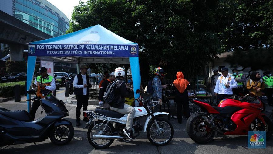 Petugas melakukan uji coba pelaksanaan tilang uji emisi kendaraan di kawasan Terminal Blok M, Jakarta, Jumat (25/8/2023). (CNBC Indonesia/Tri Susilo)