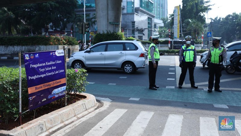 Petugas melakukan uji coba pelaksanaan tilang uji emisi kendaraan di kawasan Terminal Blok M, Jakarta, Jumat (25/8/2023). (CNBC Indonesia/Tri Susilo)