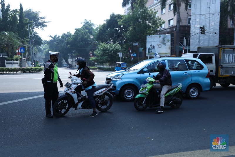 Petugas melakukan uji coba pelaksanaan tilang uji emisi kendaraan di kawasan Terminal Blok M, Jakarta, Jumat (25/8/2023). (CNBC Indonesia/Tri Susilo)