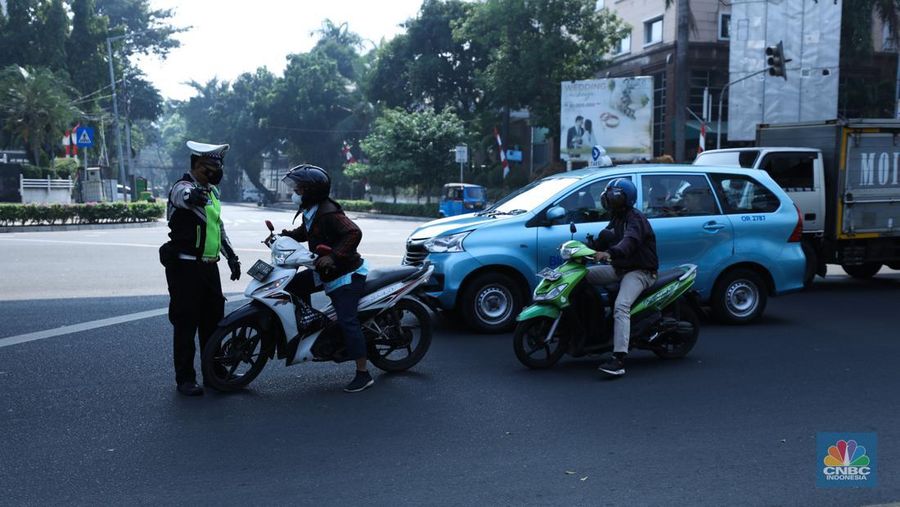 Petugas melakukan uji coba pelaksanaan tilang uji emisi kendaraan di kawasan Terminal Blok M, Jakarta, Jumat (25/8/2023). (CNBC Indonesia/Tri Susilo)