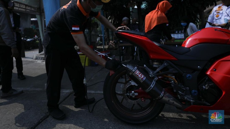 Petugas melakukan uji coba pelaksanaan tilang uji emisi kendaraan di kawasan Terminal Blok M, Jakarta, Jumat (25/8/2023). (CNBC Indonesia/Tri Susilo)