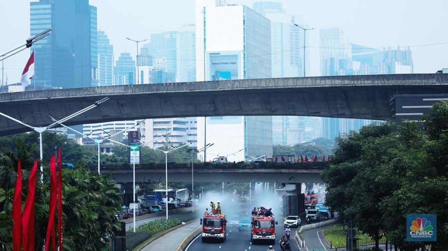 Petugas damkar menyiram jalan protokol di Kawasan Sudirman, Jakarta, Jumat (25/8). Upaya ini dilakukan untuk mengurangi dampak polusi udara di Jakarta.