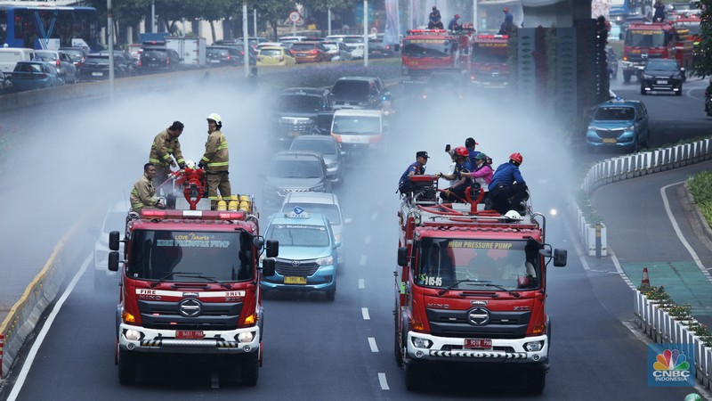 Polusi Udara Petugas damkar menyiram jalan protokol di Kawasan Sudirman, Jakarta, Jumat (25/8). Upaya ini dilakukan untuk mengurangi dampak polusi udara di Jakarta.