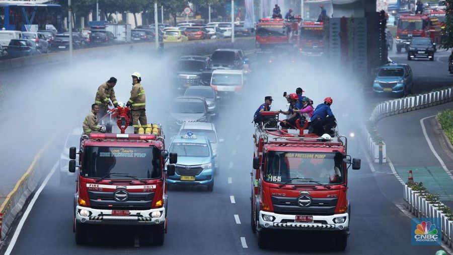 Petugas damkar menyiram jalan protokol di Kawasan Sudirman, Jakarta, Jumat (25/8). Upaya ini dilakukan untuk mengurangi dampak polusi udara di Jakarta.