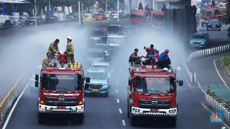 Petugas damkar menyiram jalan protokol di Kawasan Sudirman, Jakarta, Jumat (25/8). Upaya ini dilakukan untuk mengurangi dampak polusi udara di Jakarta.
