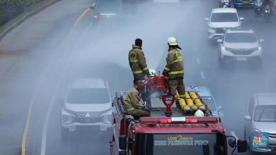 Petugas damkar menyiram jalan protokol di Kawasan Sudirman, Jakarta, Jumat (25/8). Upaya ini dilakukan untuk mengurangi dampak polusi udara di Jakarta.