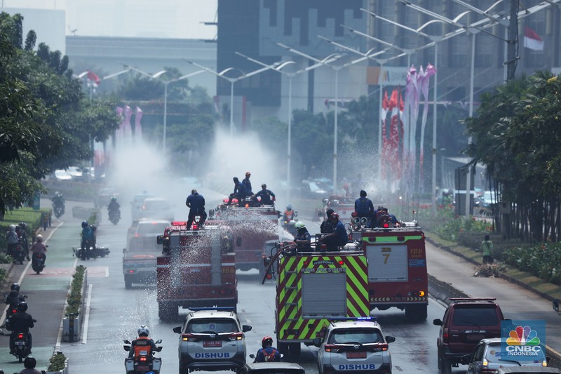 Petugas damkar menyiram jalan protokol di Kawasan Sudirman, Jakarta, Jumat (25/8). Upaya ini dilakukan untuk mengurangi dampak polusi udara di Jakarta.