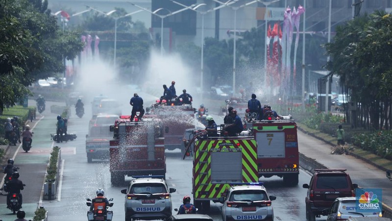 Petugas damkar menyiram jalan protokol di Kawasan Sudirman, Jakarta, Jumat (25/8). Upaya ini dilakukan untuk mengurangi dampak polusi udara di Jakarta.