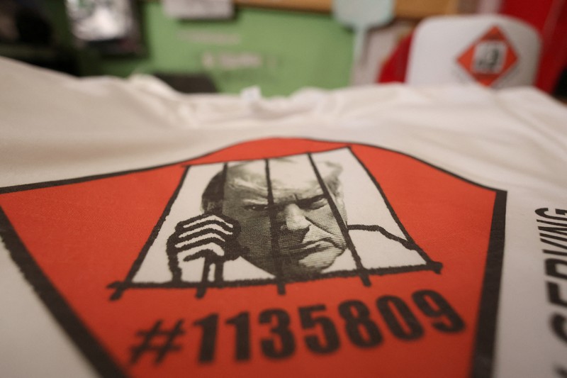 Foto mantan Presiden AS Donald Trump, yang diposting pengadilan Georgia muncul dalam berbagai merchandise seperti gelas, poster, hingga t-shirt. (REUTERS/Mario Anzuoni) Foto mantan Presiden AS Donald Trump, yang diposting pengadilan Georgia muncul dalam berbagai merchandise seperti gelas, poster, hingga t-shirt.
(REUTERS/Mario Anzuoni)