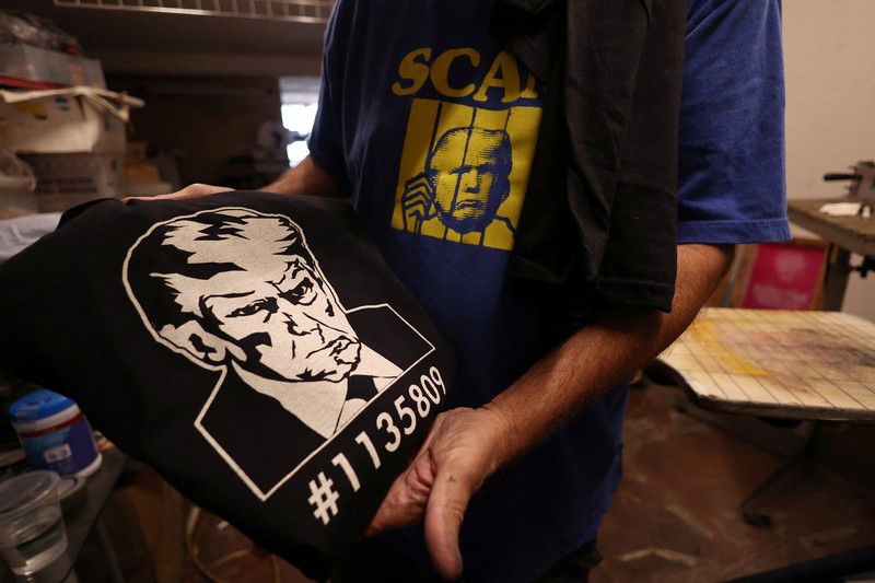 Foto mantan Presiden AS Donald Trump, yang diposting pengadilan Georgia muncul dalam berbagai merchandise seperti gelas, poster, hingga t-shirt. (REUTERS/Mario Anzuoni) Foto mantan Presiden AS Donald Trump, yang diposting pengadilan Georgia muncul dalam berbagai merchandise seperti gelas, poster, hingga t-shirt.
(REUTERS/Mario Anzuoni)