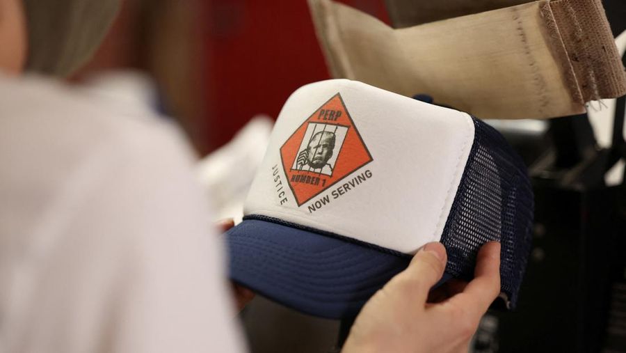 Foto mantan Presiden AS Donald Trump, yang diposting pengadilan Georgia muncul dalam berbagai merchandise seperti gelas, poster, hingga t-shirt.
(REUTERS/Mario Anzuoni)