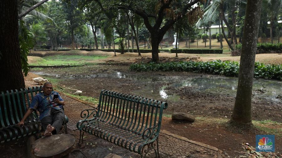 Seorang pekerja membersihkan kolam yang kering di kawasan Taman Meruya Ilir Jakarta, Senin (28/8/2023). Musim kemarau yang berkepanjangan mengakibatkan kolam-kolam di taman Jakarta mengalami kekeringan. (CNBC Indonesia/Tri Susilo)