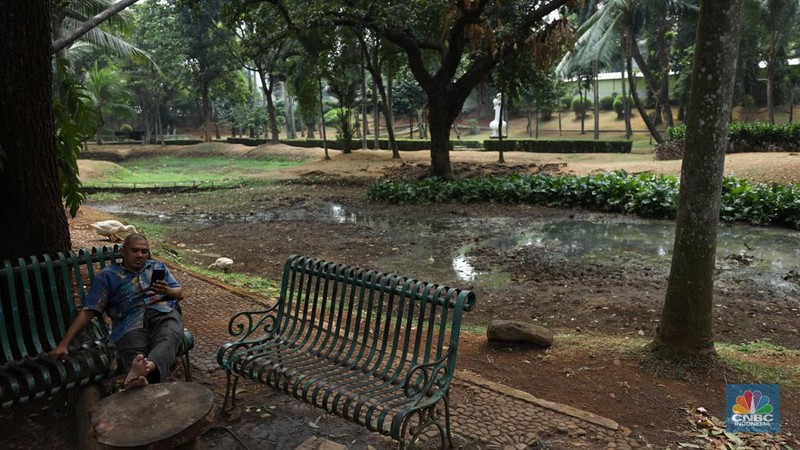 Seorang pekerja membersihkan kolam yang kering di kawasan Taman Meruya Ilir Jakarta, Senin (28/8/2023). Musim kemarau yang berkepanjangan mengakibatkan kolam-kolam di taman Jakarta mengalami kekeringan. (CNBC Indonesia/Tri Susilo)
