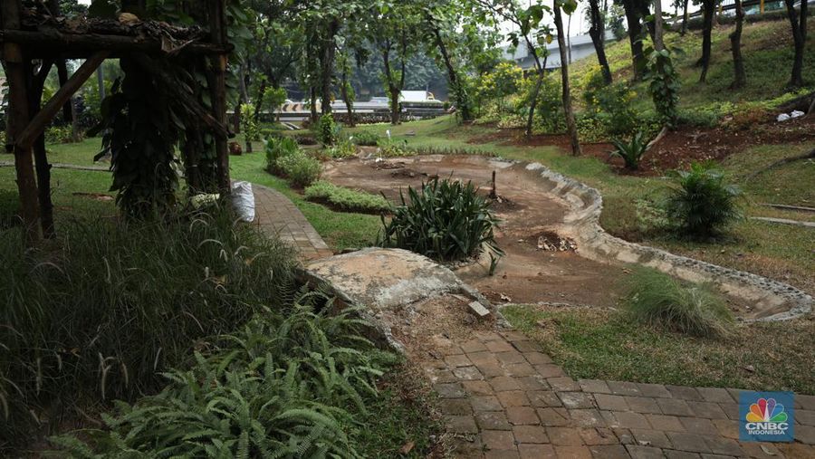 Seorang pekerja membersihkan kolam yang kering di kawasan Taman Meruya Ilir Jakarta, Senin (28/8/2023). Musim kemarau yang berkepanjangan mengakibatkan kolam-kolam di taman Jakarta mengalami kekeringan. (CNBC Indonesia/Tri Susilo)