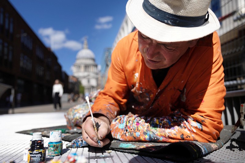 Ben Wilson, seniman, melukis di Millennium Bridge, London, Inggris, 21 Agustus 2023. Ben Wilson, seniman, melukis di Millennium Bridge, London, Inggris, 21 Agustus 2023. (REUTERS/Anna Gordon)