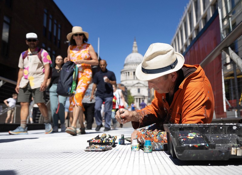 Ben Wilson, seniman, melukis di Millennium Bridge, London, Inggris, 21 Agustus 2023. Ben Wilson, seniman, melukis di Millennium Bridge, London, Inggris, 21 Agustus 2023. (REUTERS/Anna Gordon)