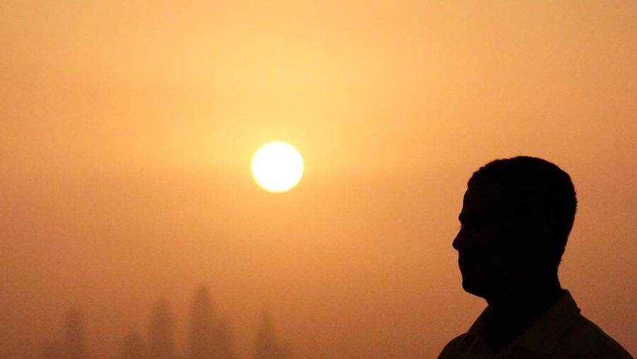 Lifeguard Mohamed stands near a swimming pool while the sun sets over Dubai, United Arab Emirates, August 12, 2023. REUTERS/Amr Alfiky
