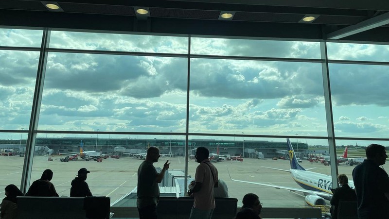 Seorang anggota staf British Airways berbicara kepada penumpang di Bandara Heathrow, ketika Layanan Lalu Lintas Udara Nasional Inggris (NATS) membatasi lalu lintas udara Inggris karena masalah teknis yang menyebabkan penundaan, di London, Inggris, 28 Agustus 2023. (REUTERS/Hollie Adams)