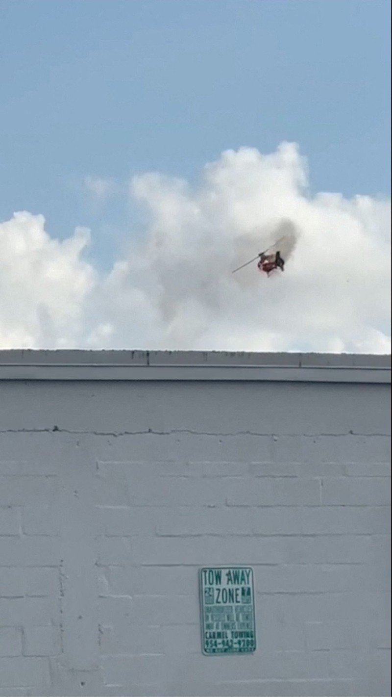 Sebuah helikopter terbakar berputar di udara sebelum menabrak kompleks apartemen, di Pantai Pompano, Florida, AS, 28 Agustus 2023, dalam gambar diam dari video yang diperoleh dari media sosial. (@guiamiamivip via TMX/via REUTERS)