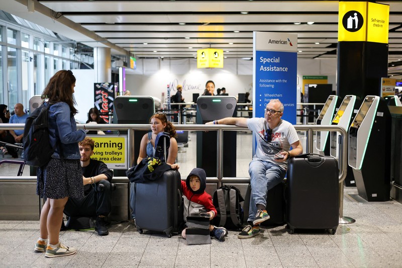 Seorang anggota staf British Airways berbicara kepada penumpang di Bandara Heathrow, ketika Layanan Lalu Lintas Udara Nasional Inggris (NATS) membatasi lalu lintas udara Inggris karena masalah teknis yang menyebabkan penundaan, di London, Inggris, 28 Agustus 2023. Seorang anggota staf British Airways berbicara kepada penumpang di Bandara Heathrow, ketika Layanan Lalu Lintas Udara Nasional Inggris (NATS) membatasi lalu lintas udara Inggris karena masalah teknis yang menyebabkan penundaan, di London, Inggris, 28 Agustus 2023. (REUTERS/Hollie Adams)