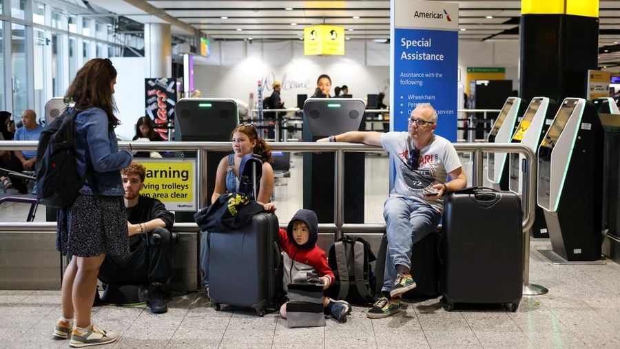 Seorang anggota staf British Airways berbicara kepada penumpang di Bandara Heathrow, ketika Layanan Lalu Lintas Udara Nasional Inggris (NATS) membatasi lalu lintas udara Inggris karena masalah teknis yang menyebabkan penundaan, di London, Inggris, 28 Agustus 2023. (REUTERS/Hollie Adams)