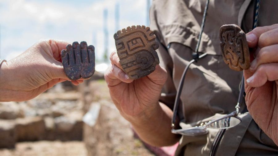 Para arkeolog dari Proyek Arkeologi Pacopampa memegang potongan tembikar dari makam berusia 3.000 tahun yang mereka yakini mungkin merupakan penghormatan kepada pemimpin agama elit di negara Andean sekitar tiga milenium lalu, di Pacopampa, Peru, 26 Agustus 2023. (Ministry of Culture of Peru/Handout via REUTERS)