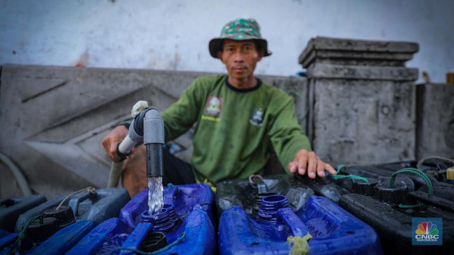 Pekerja mengisi air bersih ke dalam jerigen untuk dijual di kawasan Muara Angke, Jakarta Utara, Senin (30/8/2023). (CNBC Indonesia/Faisal Rahman)