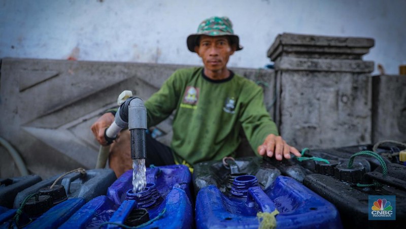 Pekerja mengisi air bersih ke dalam jerigen untuk dijual di kawasan Muara Angke, Jakarta Utara, Senin (30/8/2023). (CNBC Indonesia/Faisal Rahman)