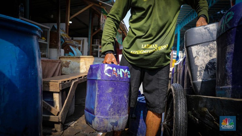 Pekerja mengisi air bersih ke dalam jerigen untuk dijual di kawasan Muara Angke, Jakarta Utara, Senin (30/8/2023). (CNBC Indonesia/Faisal Rahman)
