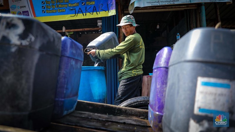 Pekerja mengisi air bersih ke dalam jerigen untuk dijual di kawasan Muara Angke, Jakarta Utara, Senin (30/8/2023). (CNBC Indonesia/Faisal Rahman)